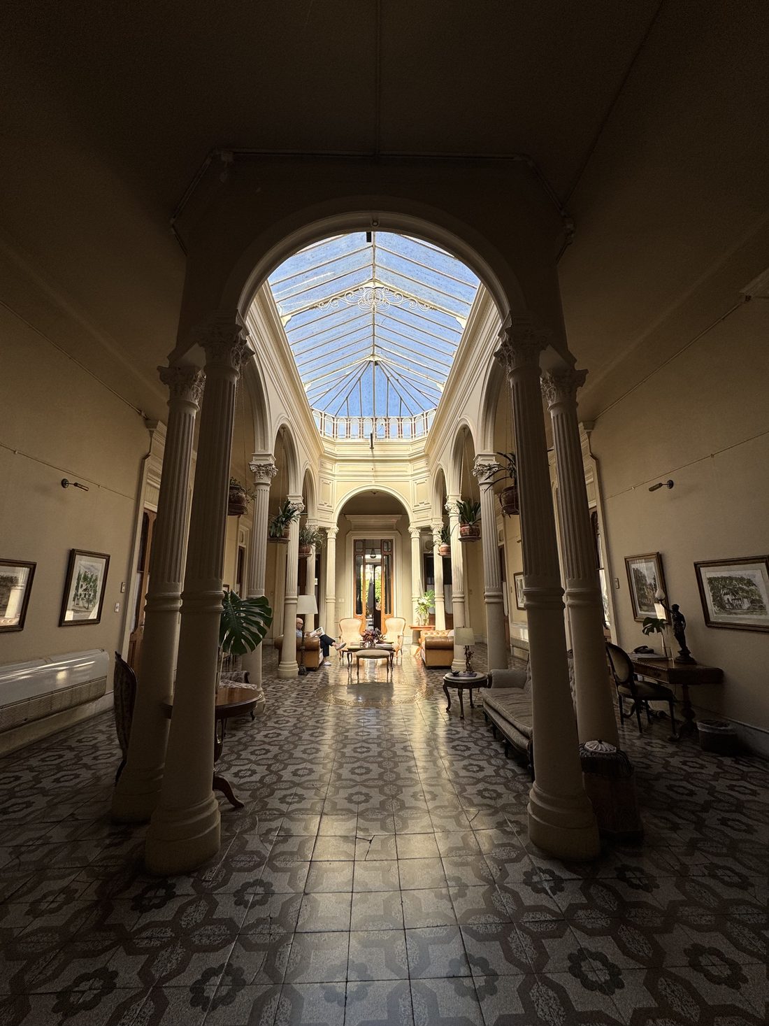Patio cubierto con columnas, claraboya de vidrio y piso de baldosa hidráulica