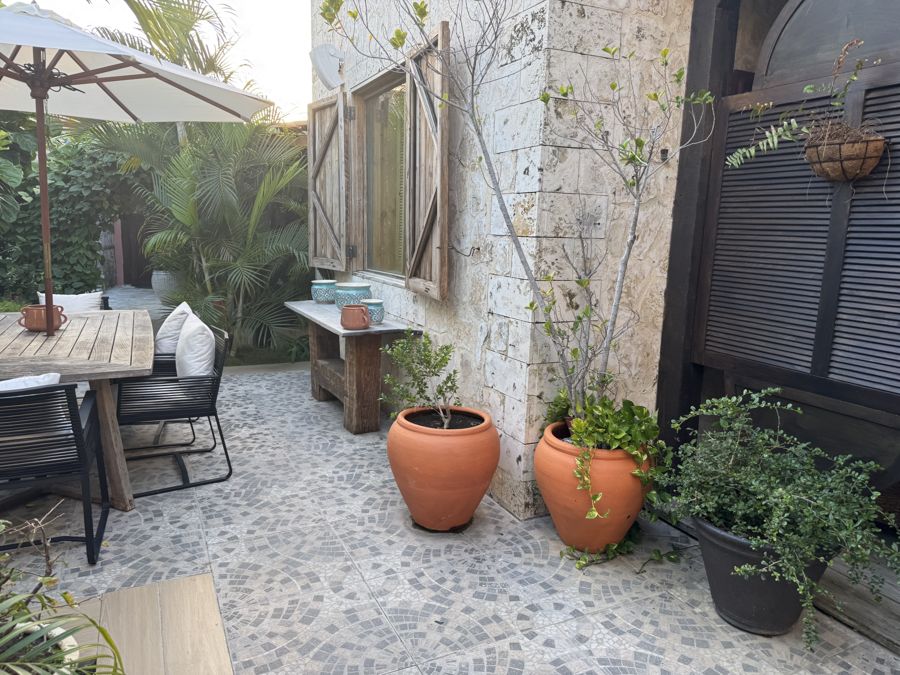 Patio con materas de terracota y muro de piedra